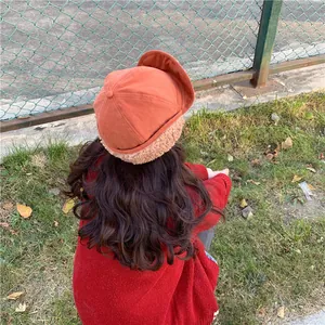 Detailed back view of an orange trapper hat featuring warm beige sherpa plush lining