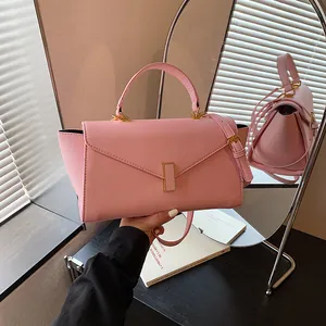 Detailed macro view of a pink textured leather handbag featuring elegant gold-tone hardware.