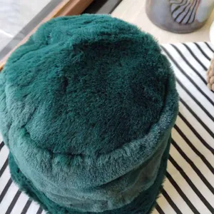 Close-up of deep green faux fur bucket hat showing soft plush texture and thick material.