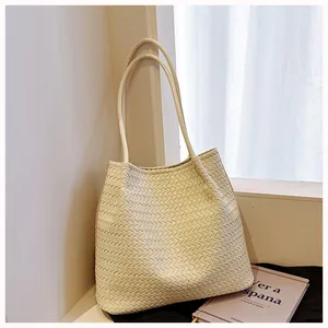 Detail view of a retro cream woven tote bag placed in a minimalist indoor setting