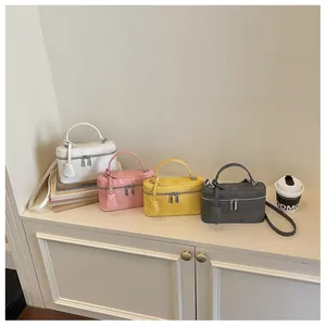 Collection of mini box crossbody bags in white, pink, yellow and grey with suede texture.