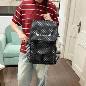 Stylish black backpack featuring white star patterns and a cute plush bear charm.