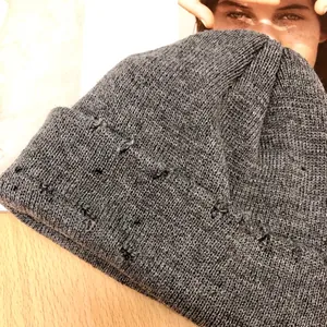 Gros plan d'un bonnet en tricot gris vieilli montrant la texture côtelée et le style vintage
