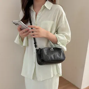 Vue lifestyle d'un sac bandoulière noir minimaliste avec une finition en cuir texturé