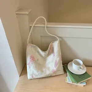 Close-up of elegant floral embroidery on a white Chinese-style bucket bag