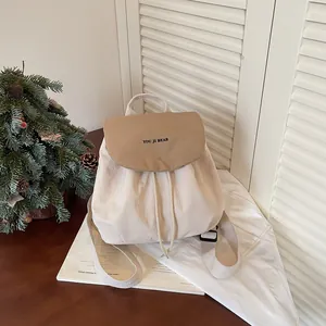 Gros plan d'un sac à dos en toile crème élégant avec rabat marron et cordon de serrage
