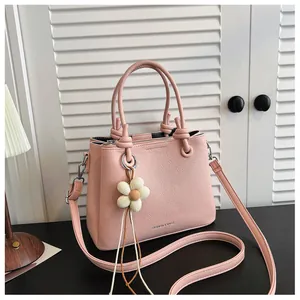 Detalle del bolso de cubo rosa en cuero granulado con bonito adorno de flor colgante hoy