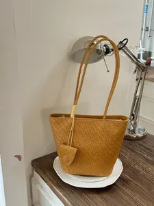Elegante gele geweven draagtas voor dames met een stijlvol minimalistisch schouderontwerp
