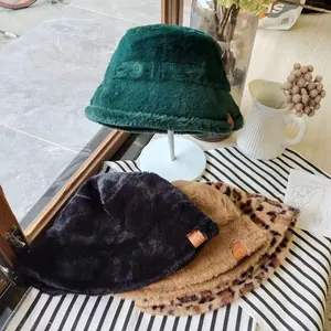 Close-up of soft faux fur bucket hats in green, black, camel, and leopard patterns