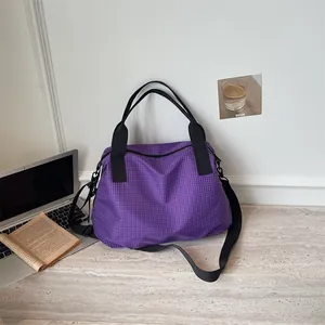Borsa da viaggio grande a scacchi viola per sport presentata in un contesto lifestyle raffinato.