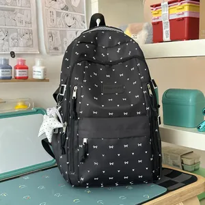 Gedetailleerd overzicht van een zwarte schoolrugzak met leuke witte strikpatronen