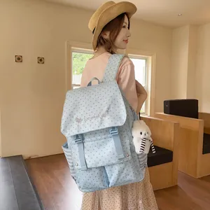 Detailed macro view of a fashionable light blue star pattern backpack worn by a model