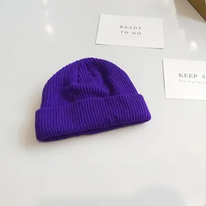 Detailed view of a stylish purple ribbed knit beanie showing soft texture and folded brim