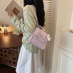 Vista posteriore di una modella con uno zaino viola chiaro con dettagli a fiocco