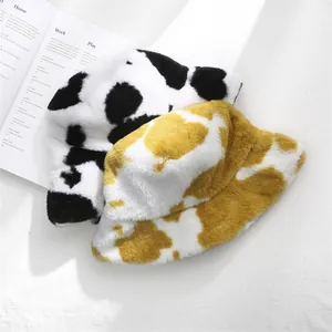 Stylish faux fur cow print bucket hats in black and yellow for cozy winter fashion