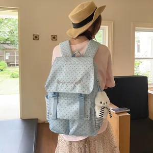 Back view of a light blue star pattern backpack with a plush rabbit charm on a model