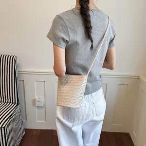 Rückansicht einer minimalistischen cremefarbenen geflochtenen Eimertasche als Crossbody