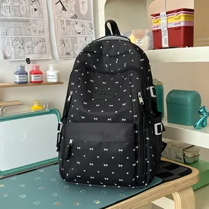 Leuke zwarte schoolrugzak in Japanse stijl met witte strikpatronen op een bureau.