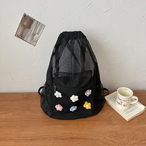Lifestyle view of black mesh backpack with colorful knit flowers