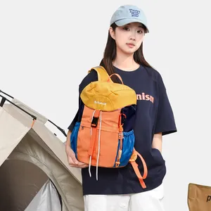 Model wearing a colorful outdoor backpack next to a camping tent in detail view