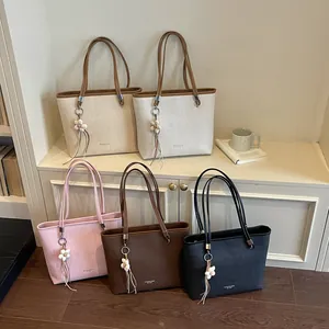 Detailed display of large capacity tote bags in multiple colors featuring floral charms