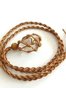 Close-up detail of natural clear quartz crystal in a handmade brown macrame net necklace