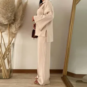 Elegante completo beige in tessuto stropicciato con camicia a maniche lunghe e pantaloni larghi