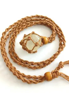 Detail view of natural crystal pendant in a hand-woven adjustable net bag necklace