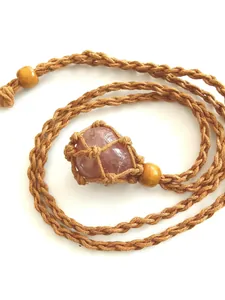 Detail of hand-woven brown net necklace with a polished pink rose quartz stone