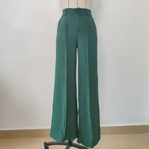 Detail view of dark green wide-leg trousers featuring an elegant high-waisted design