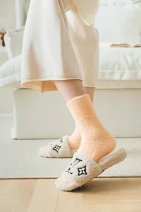 Calcetines de terciopelo de visón y zapatillas de felpa en un hogar minimalista