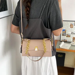 Model showing a stylish pink crossbody bag with gold chain strap in a lifestyle setting
