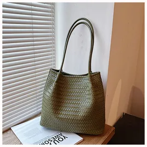 Close-up detail of the olive green woven tote bag showing its intricate retro leather texture