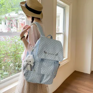 Detailed side view of a light blue star pattern backpack with a cute bunny charm