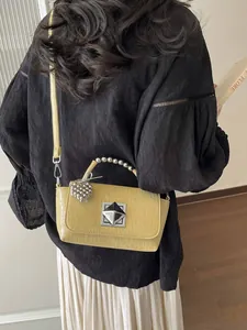 Trendy yellow textured small square crossbody bag for women featuring a beaded handle.