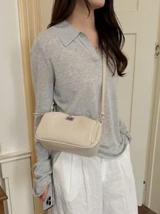 Petit sac bandoulière minimaliste de couleur crème pour femme avec boucle argentée