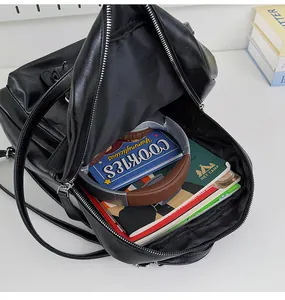 Interior view of a large black travel backpack filled with books and headphones.