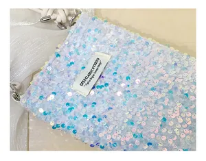 Dettaglio di un'elegante borsa per telefono in paillettes bianche iridescenti con etichetta