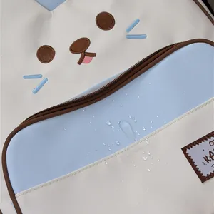 Detailed close-up showing cute cat face embroidery and water-resistant fabric on backpack