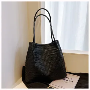 Detailed view of a large black woven shoulder bag with a classic vintage woven design.