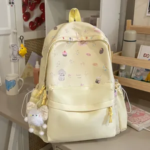 Close-up of sweet aesthetic yellow backpack featuring cute cartoon prints and plush charm
