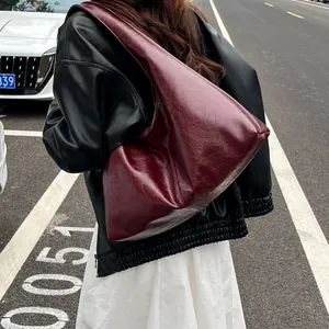 Vista detallada del gran bolso hobo granate vintage con una chaqueta de cuero negra