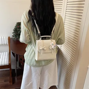 Vista posteriore di una donna che indossa uno zainetto bianco stile collegiale con fiocco