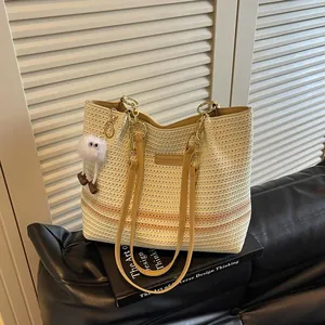 Stylish handwoven straw tote bag with elegant stripes and gold chain strap for women