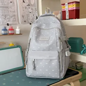 Grijze preppy rugzak met hartjesprint in een moderne studentenomgeving aan een bureau