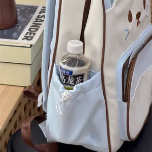 Detailed shot showing the functional side drawstring pocket of a cute cat backpack for girls.