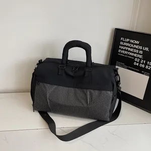 Detail view of a black travel bag with a grid-patterned lower section and sturdy handles.