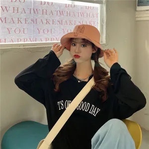 Detailed view of an Asian model wearing a cute peach bucket hat with bunny ear embroidery.