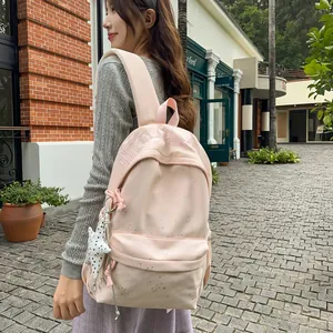 Stilvoller rosafarbener Damenrucksack mit Sternanhänger, von Model in Stadt getragen.