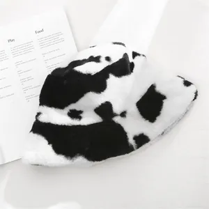 Detail view of a soft cow-print plush bucket hat with fluffy texture for winter warmth